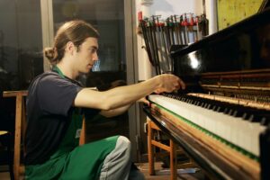 Francesco Sciurti accordatore milanese mentre registra l'action dei tasti di un pianoforte