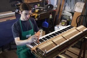 Francesco Sciurti accordatore milanese mentre regola i martelli di uno Steinway